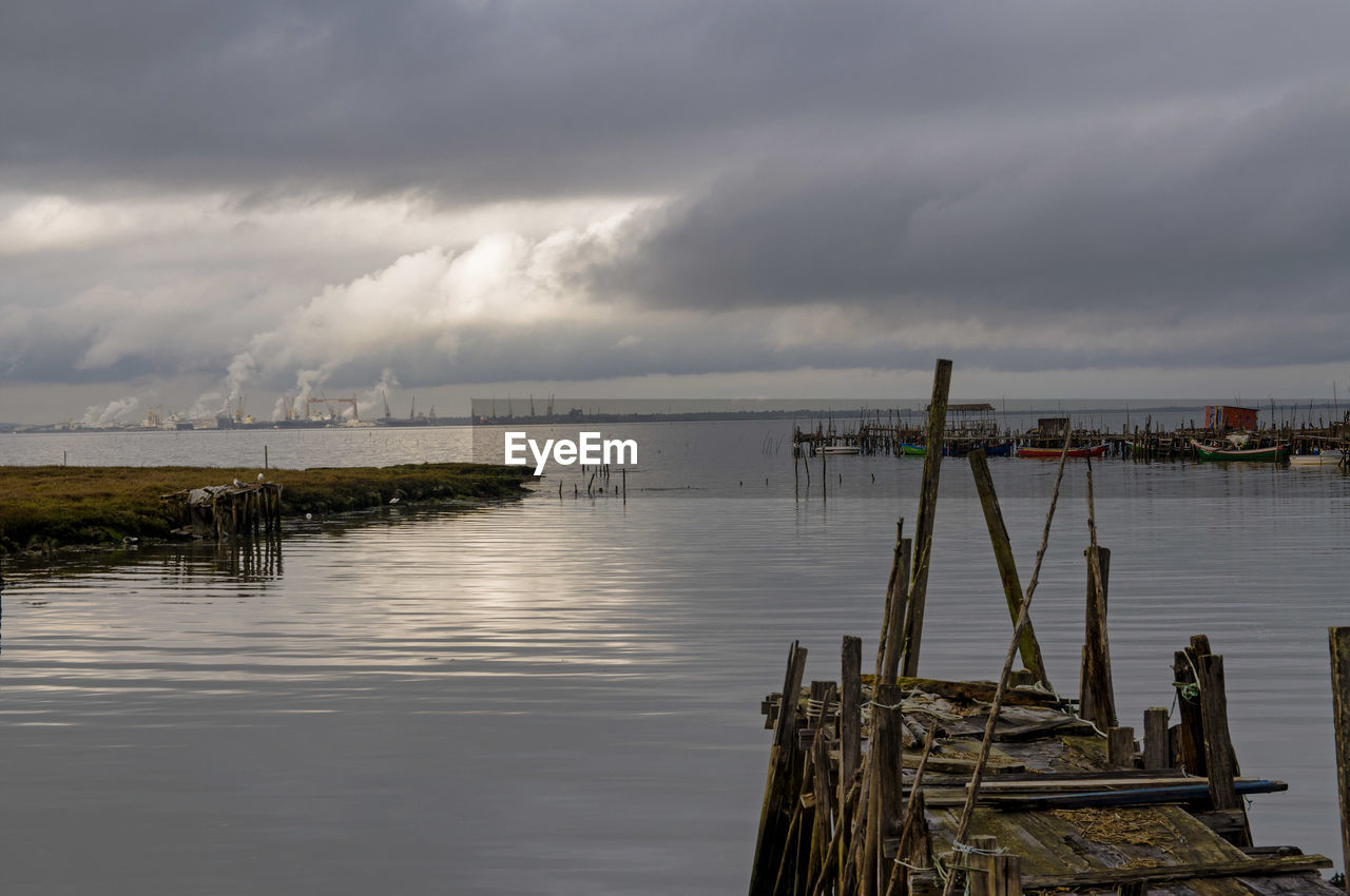 Pier on sea against cloudy sky