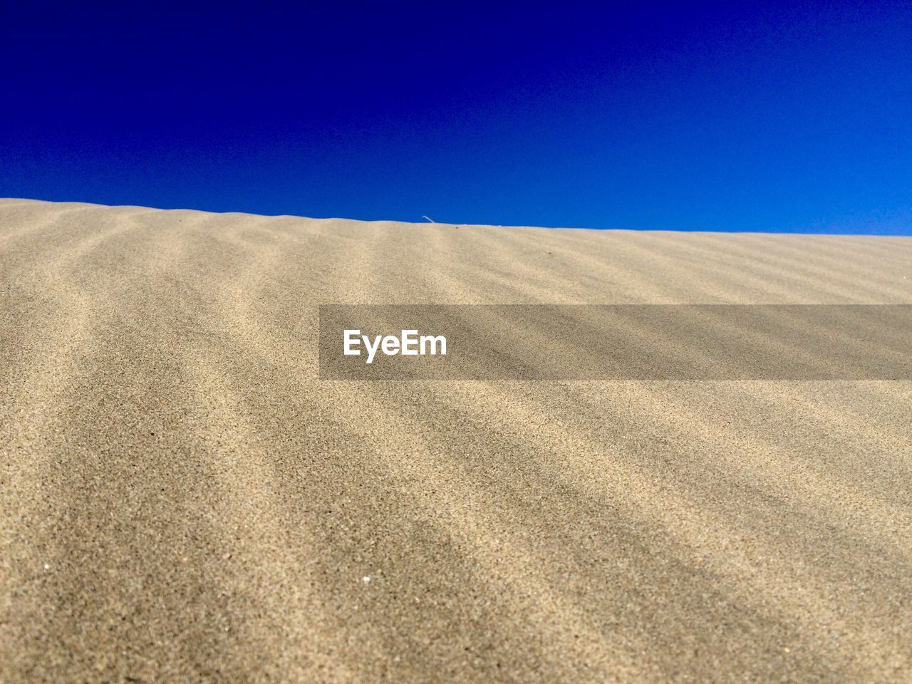 Scenic view of desert against clear blue sky