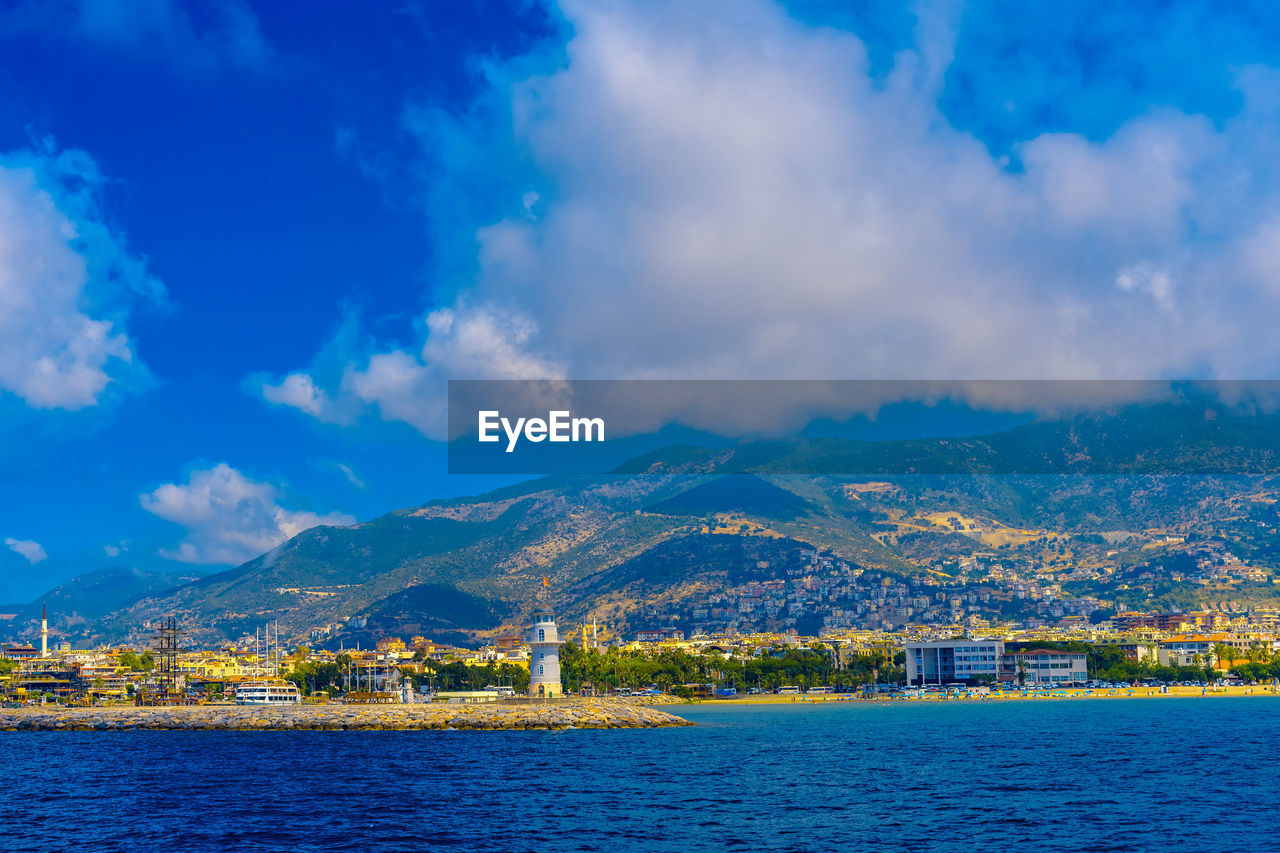 Scenic view of lake and mountains against blue sky