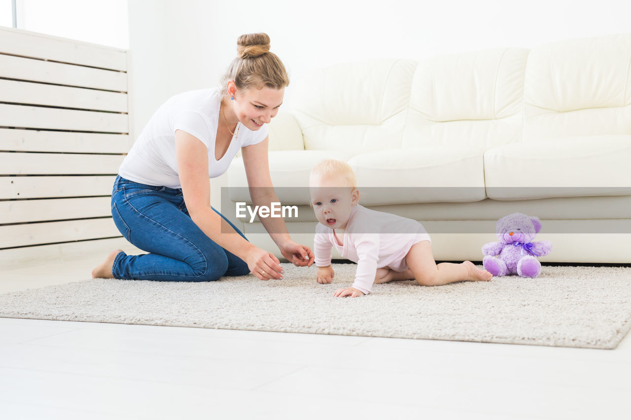MOTHER AND SON SITTING ON FLOOR AT HOME