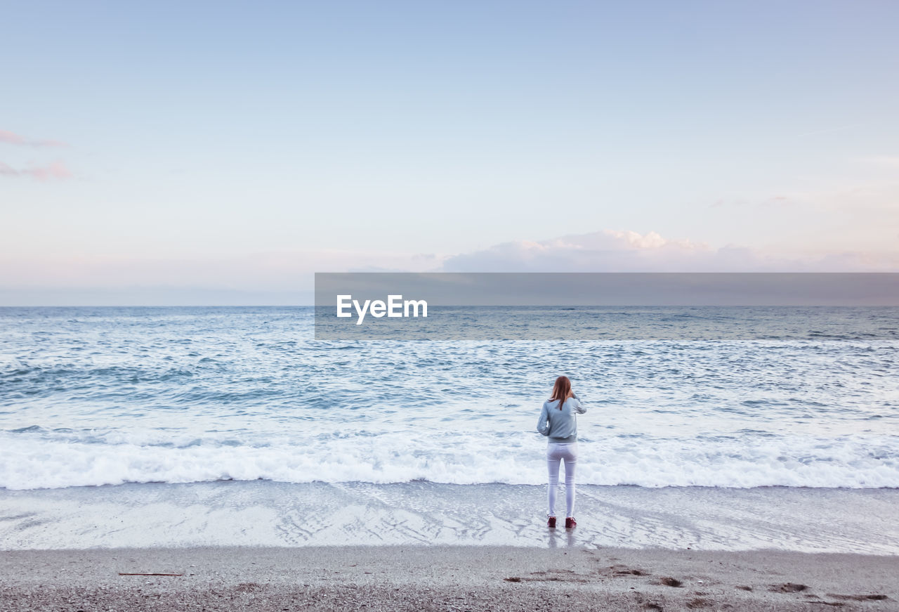 Woman looking at sea against sky