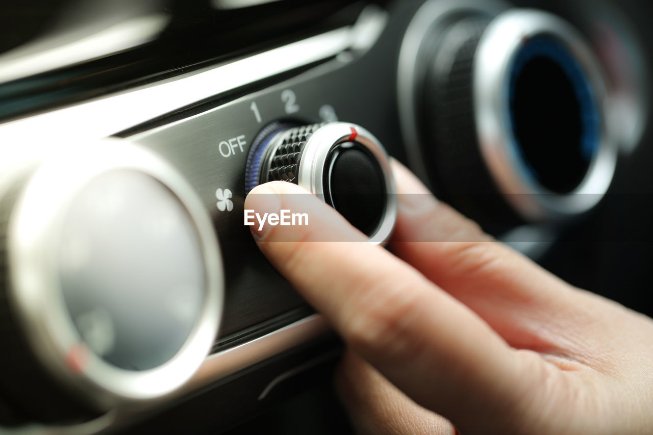 Cropped hand adjusting button in car