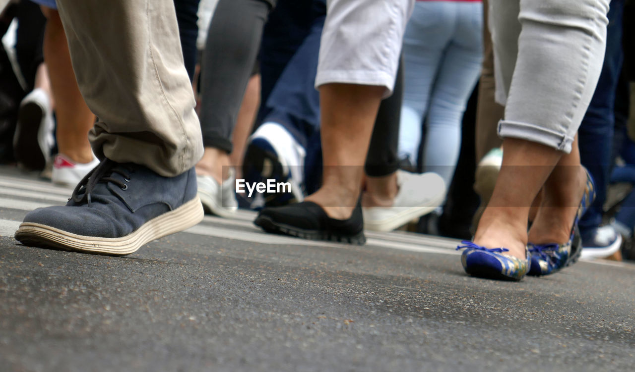 Low section of people walking on street