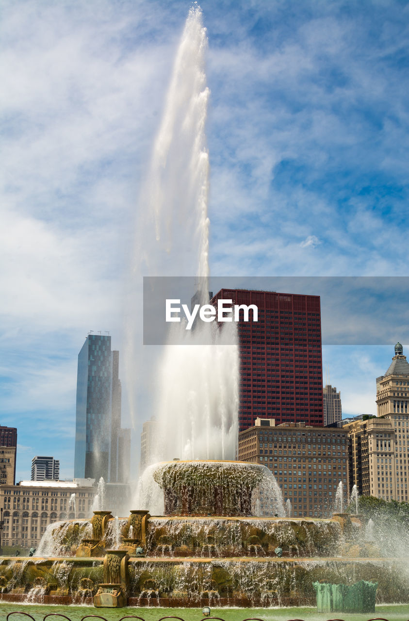 WATER FOUNTAIN AGAINST SKY IN CITY