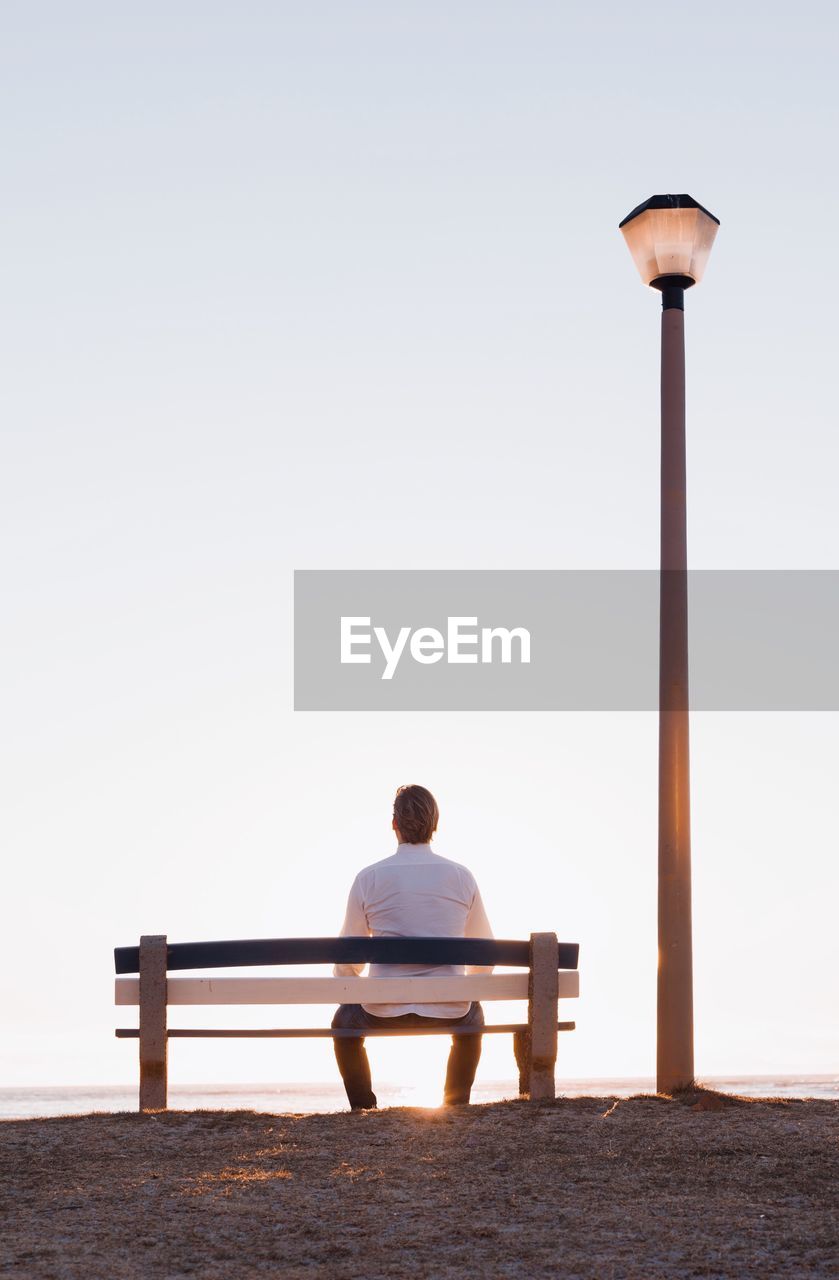 Rear view of man sitting on bench