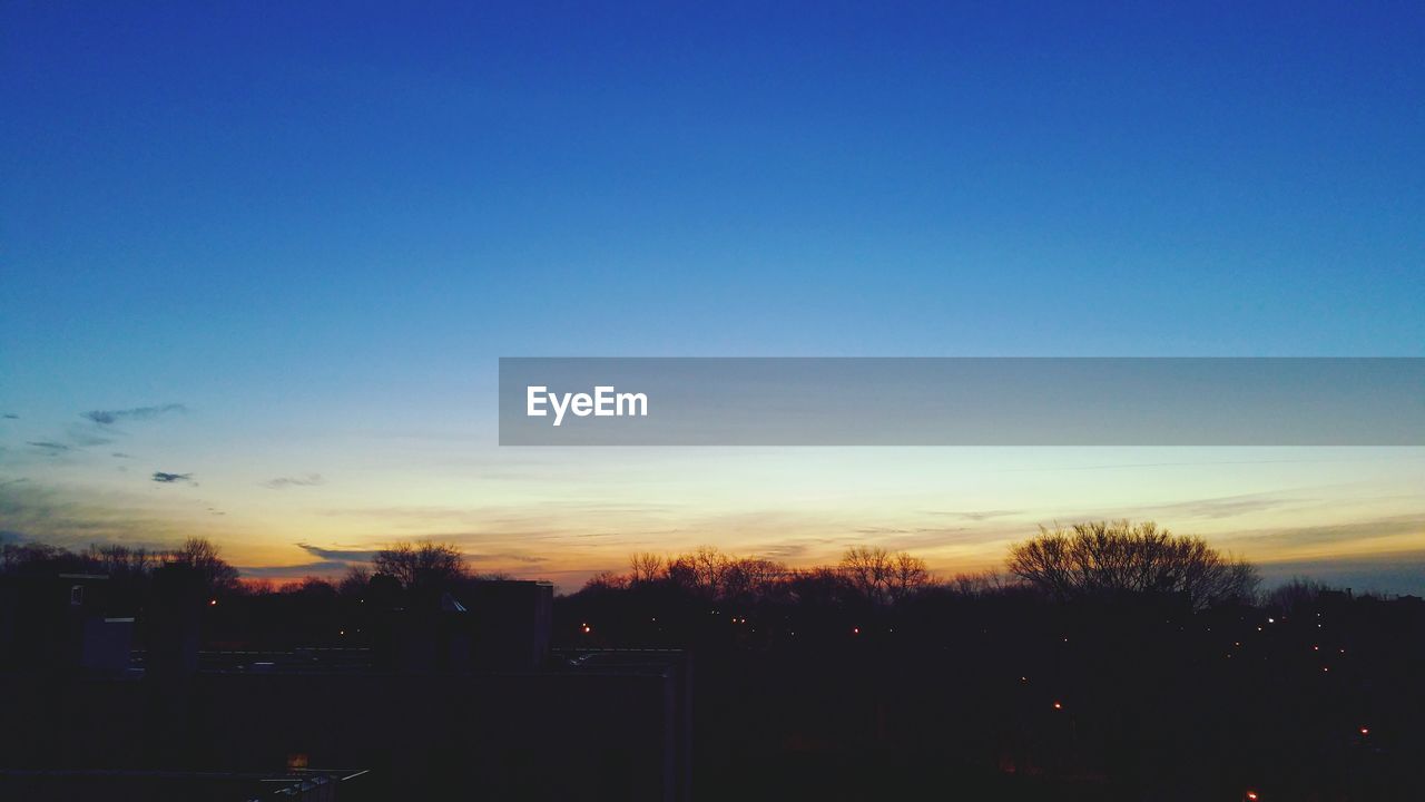 SILHOUETTE TREES AGAINST SKY AT SUNSET