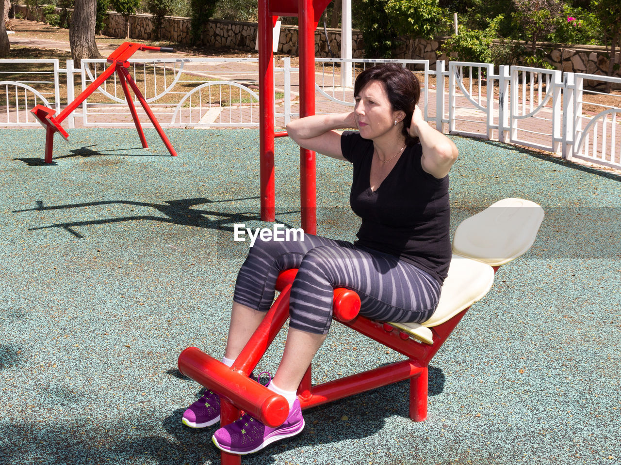 Young female athlete exercising at outdoor gym