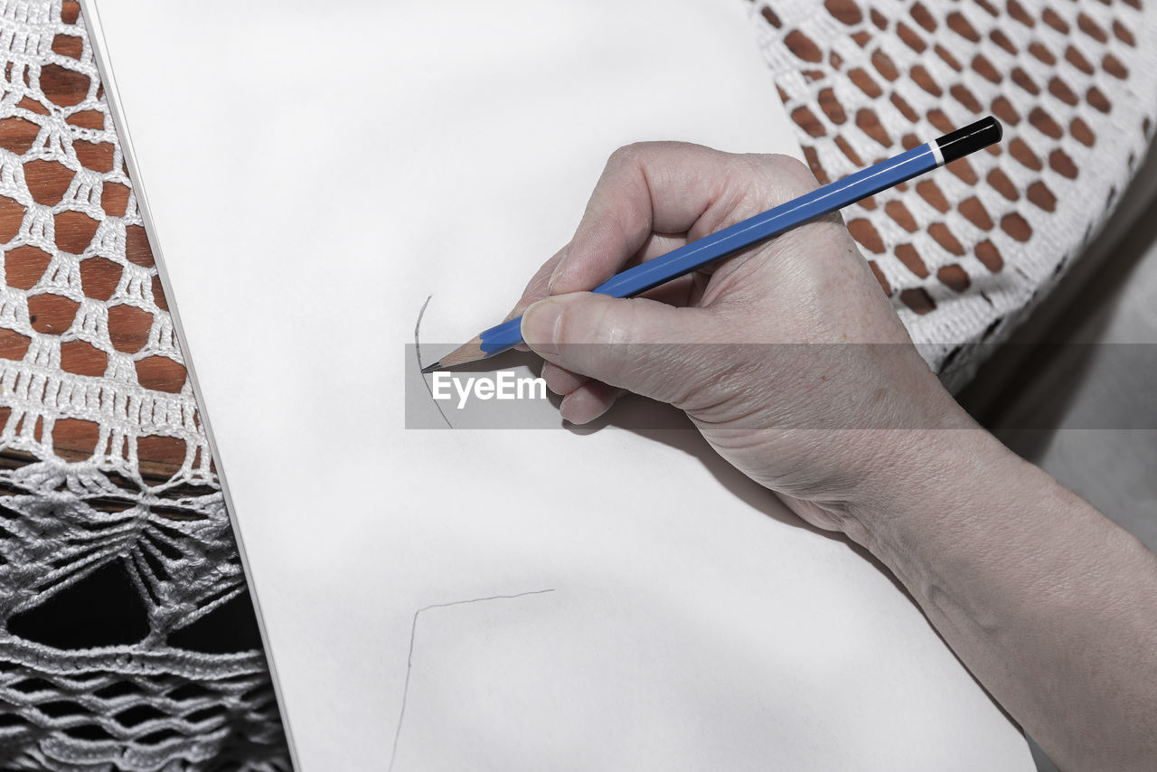 HIGH ANGLE VIEW OF WOMAN HAND PAINTING ON FLOOR