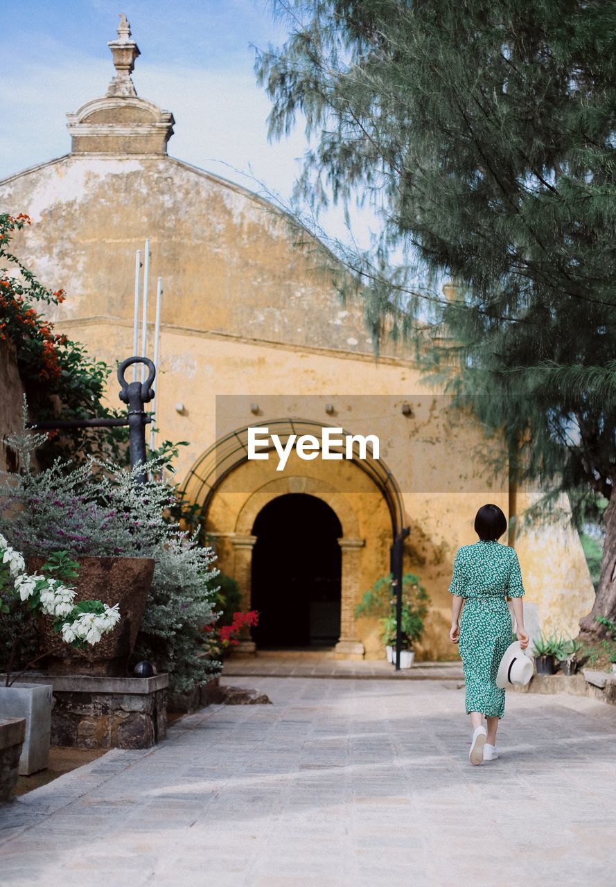 Rear view of woman walking towards historic church