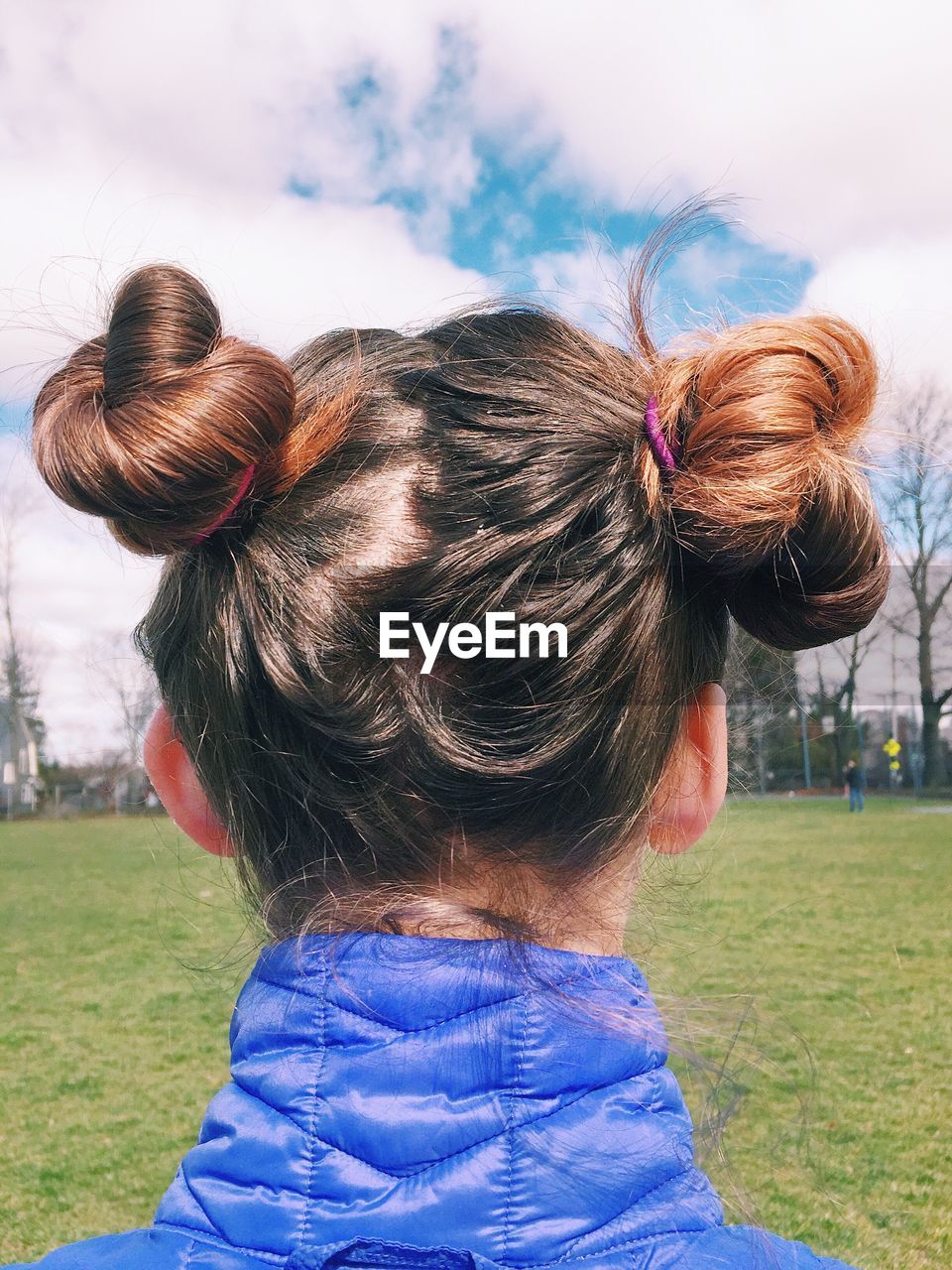 Rear view of girl on field against sky