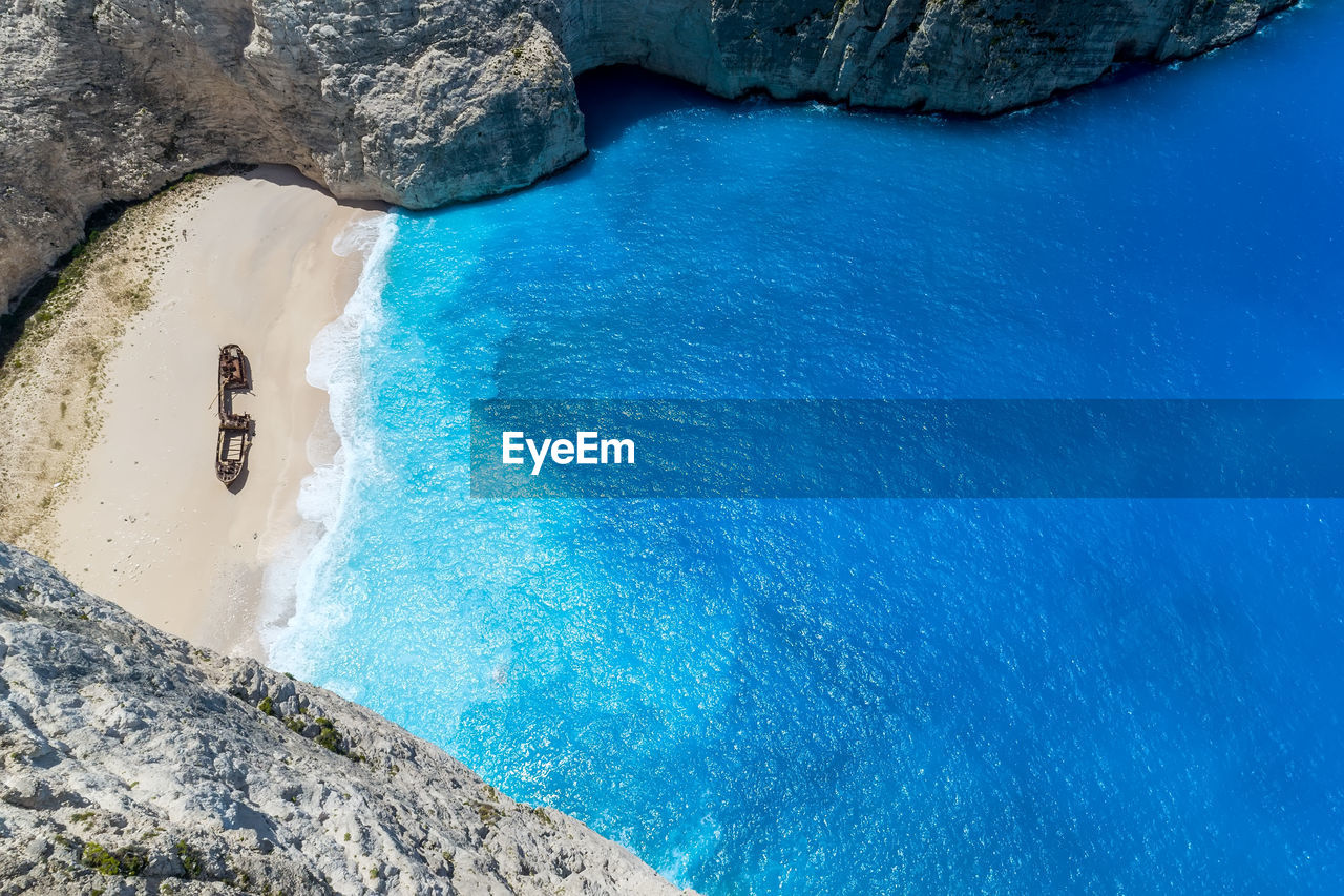 HIGH ANGLE VIEW OF ROCK FORMATIONS AT SEA