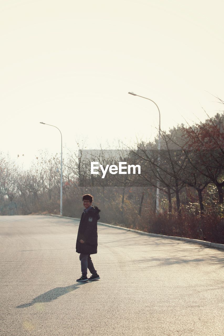 Full length of man standing on road against sky