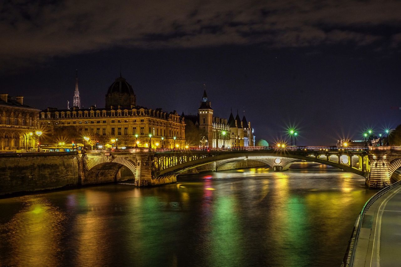 ILLUMINATED BRIDGE OVER RIVER AGAINST SKY