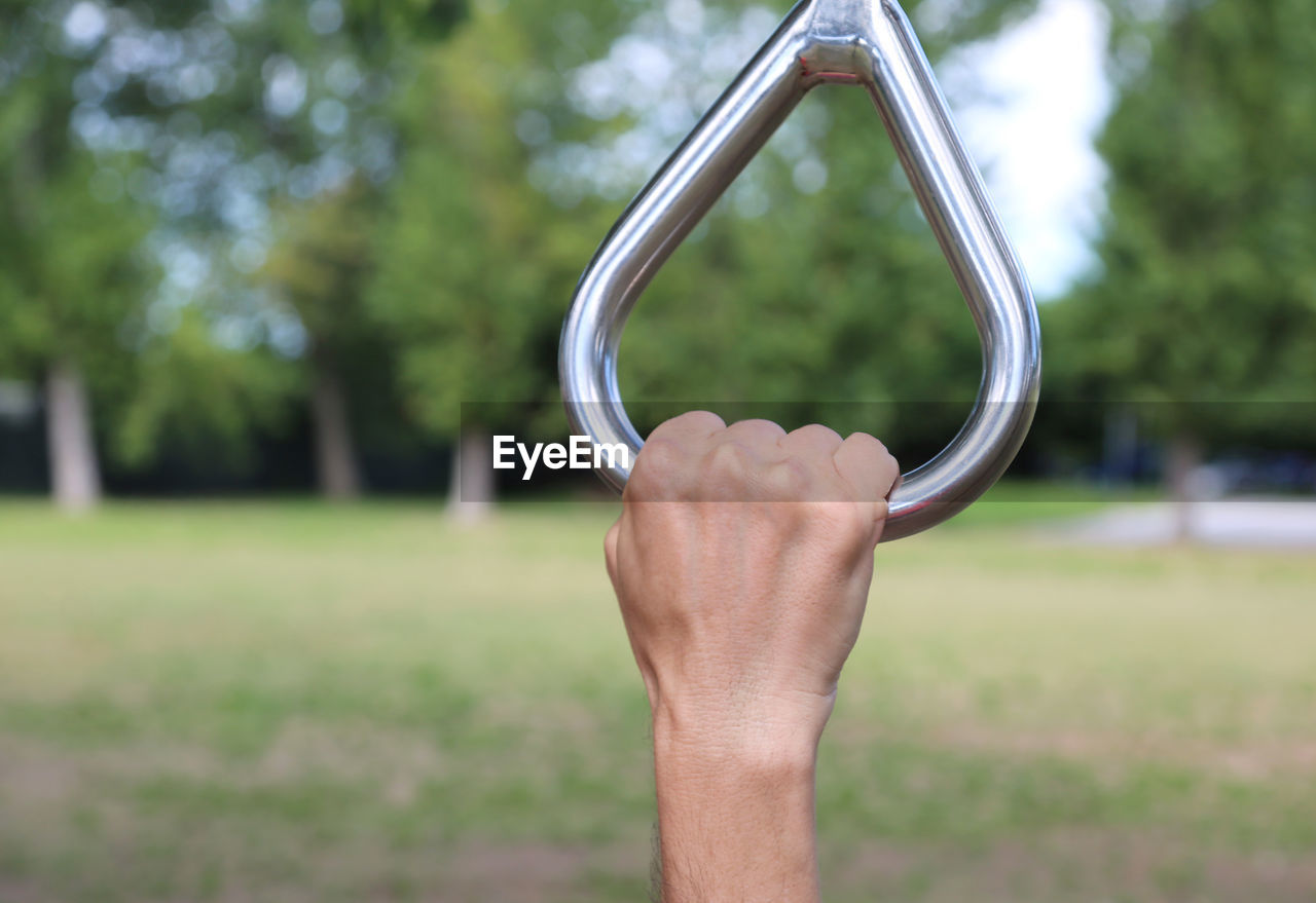 Cropped image of hand holding handle at park