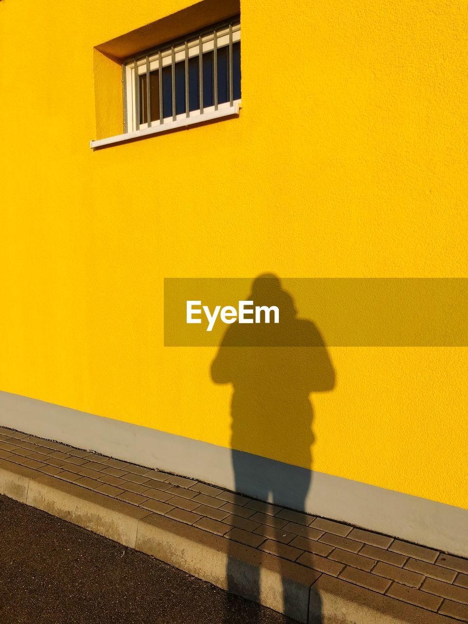 Shadow of person on yellow wall