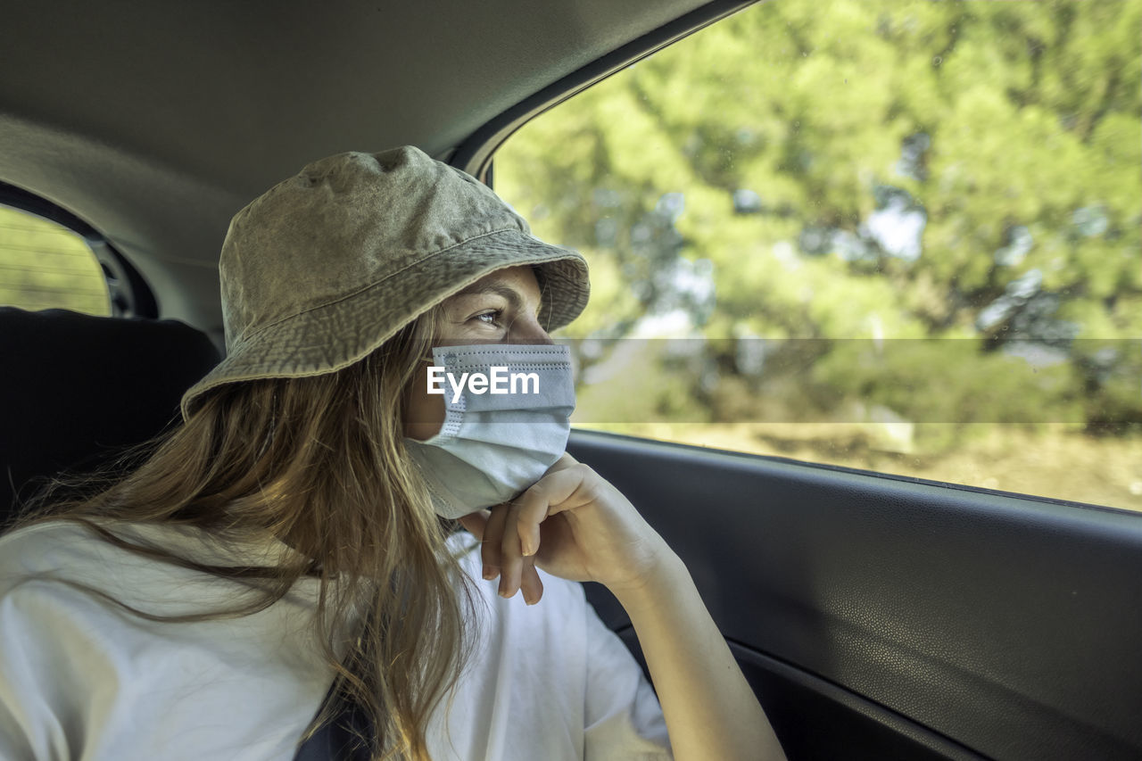 PORTRAIT OF WOMAN IN CAR SEEN THROUGH WINDOW