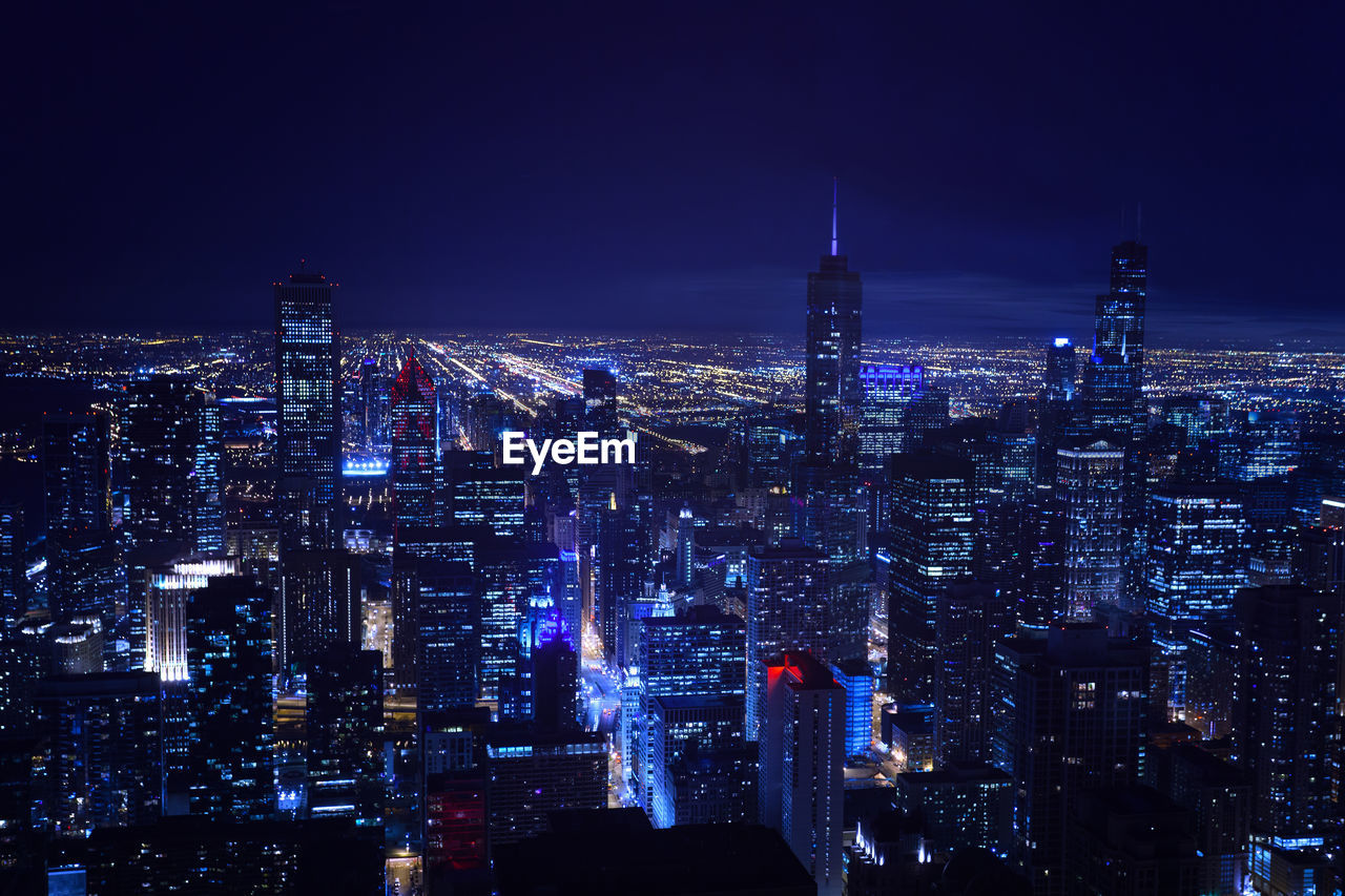 HIGH ANGLE VIEW OF ILLUMINATED CITY BUILDINGS AGAINST SKY