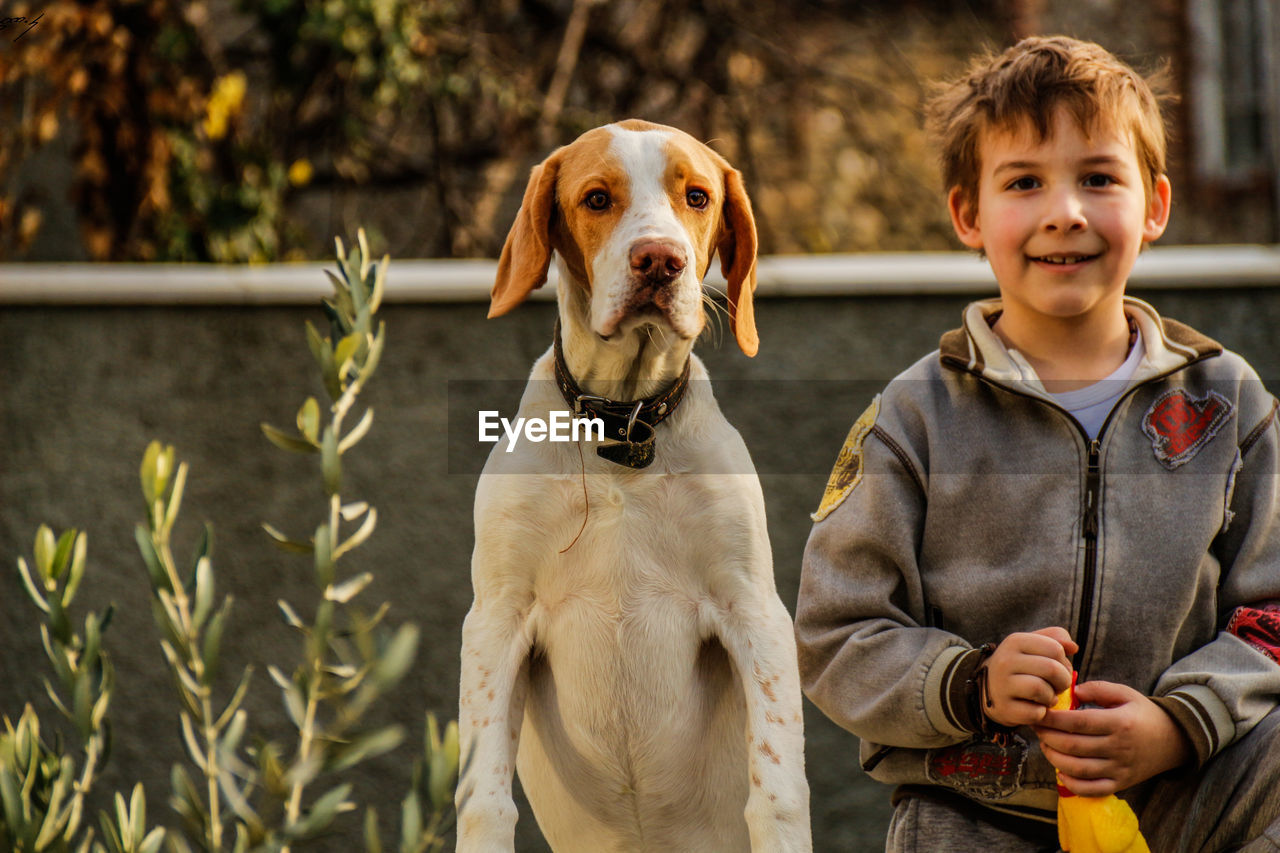 Portrait of boy with dog outdoors