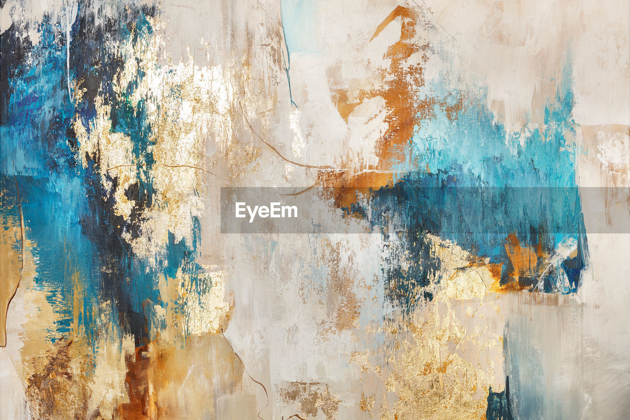 Abstract pattern in gray, beige and blue tones interspersed with gold spots.