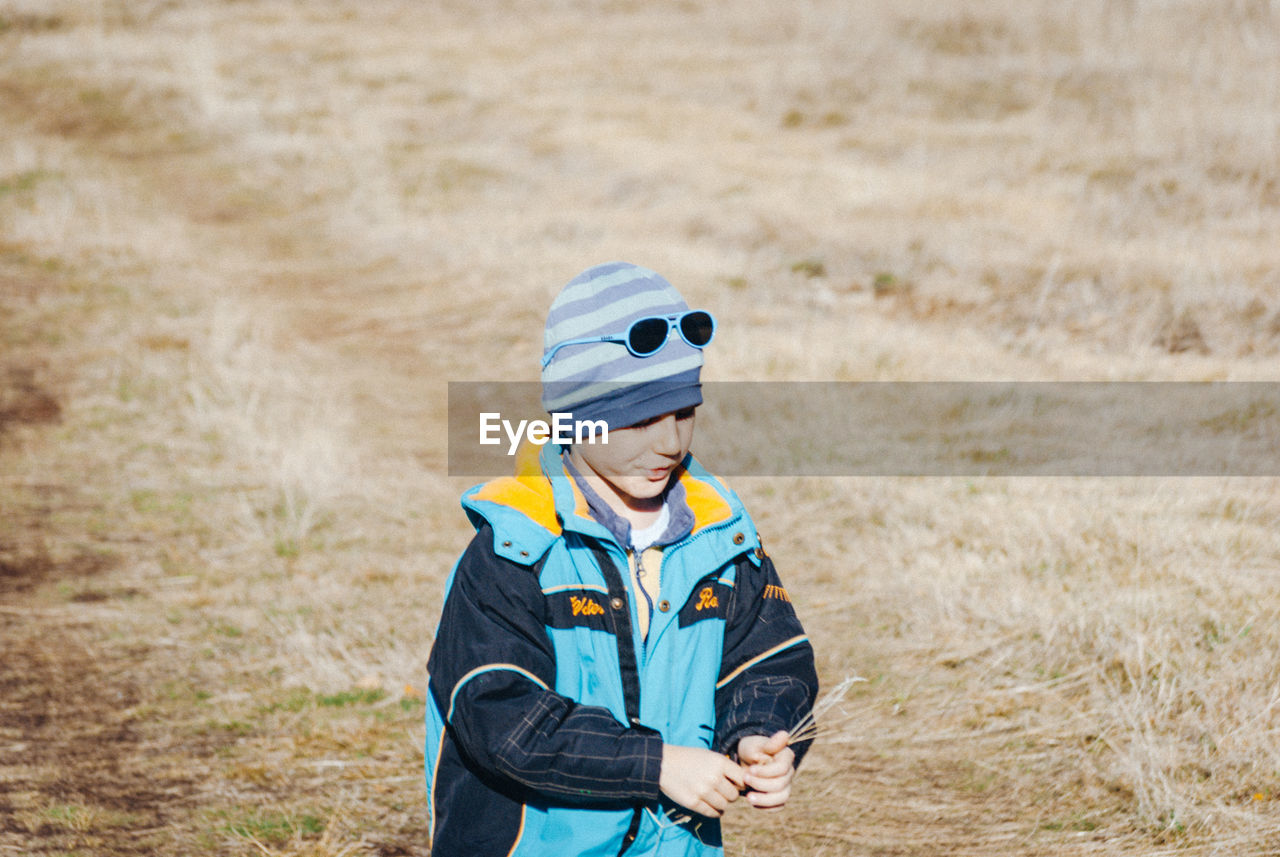 Boy standing on grassy field