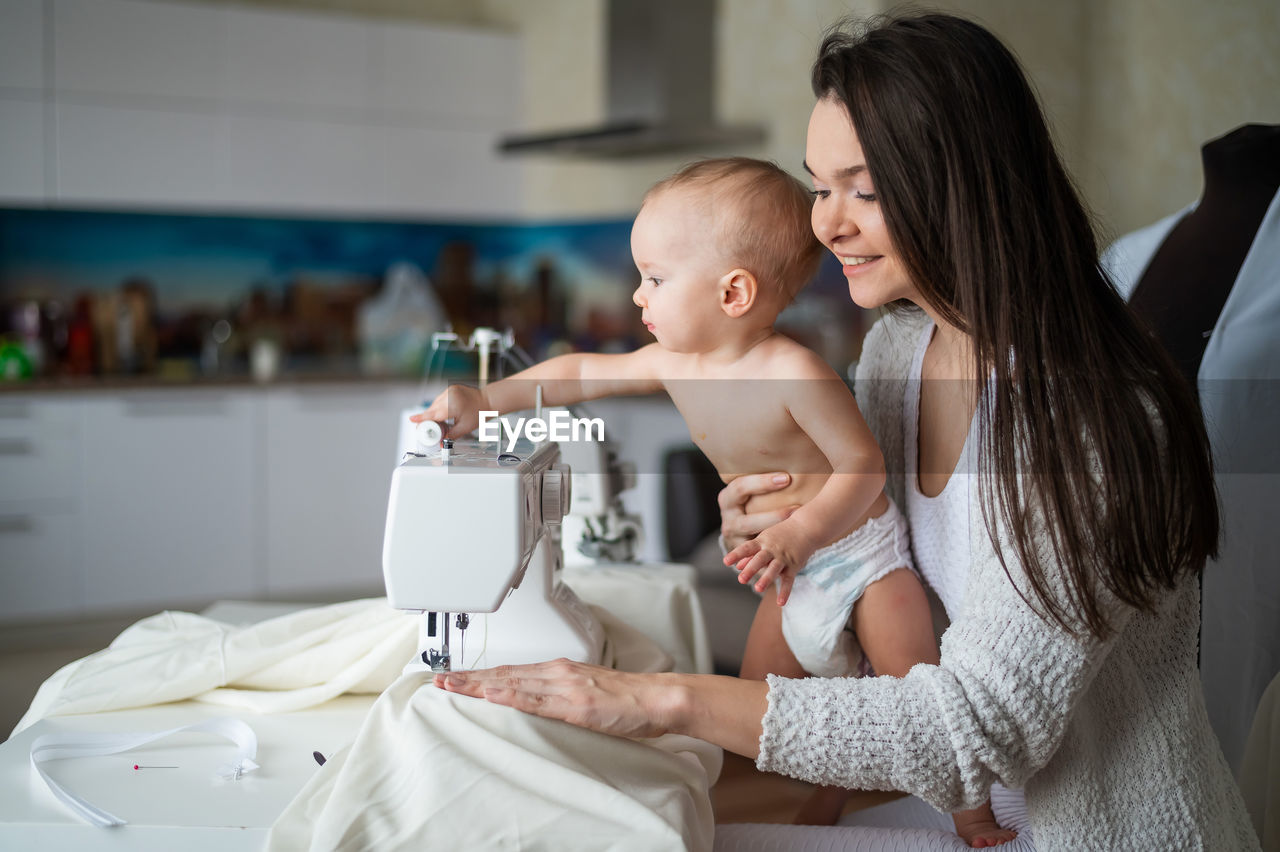 Mother and son sitting by sewing machine