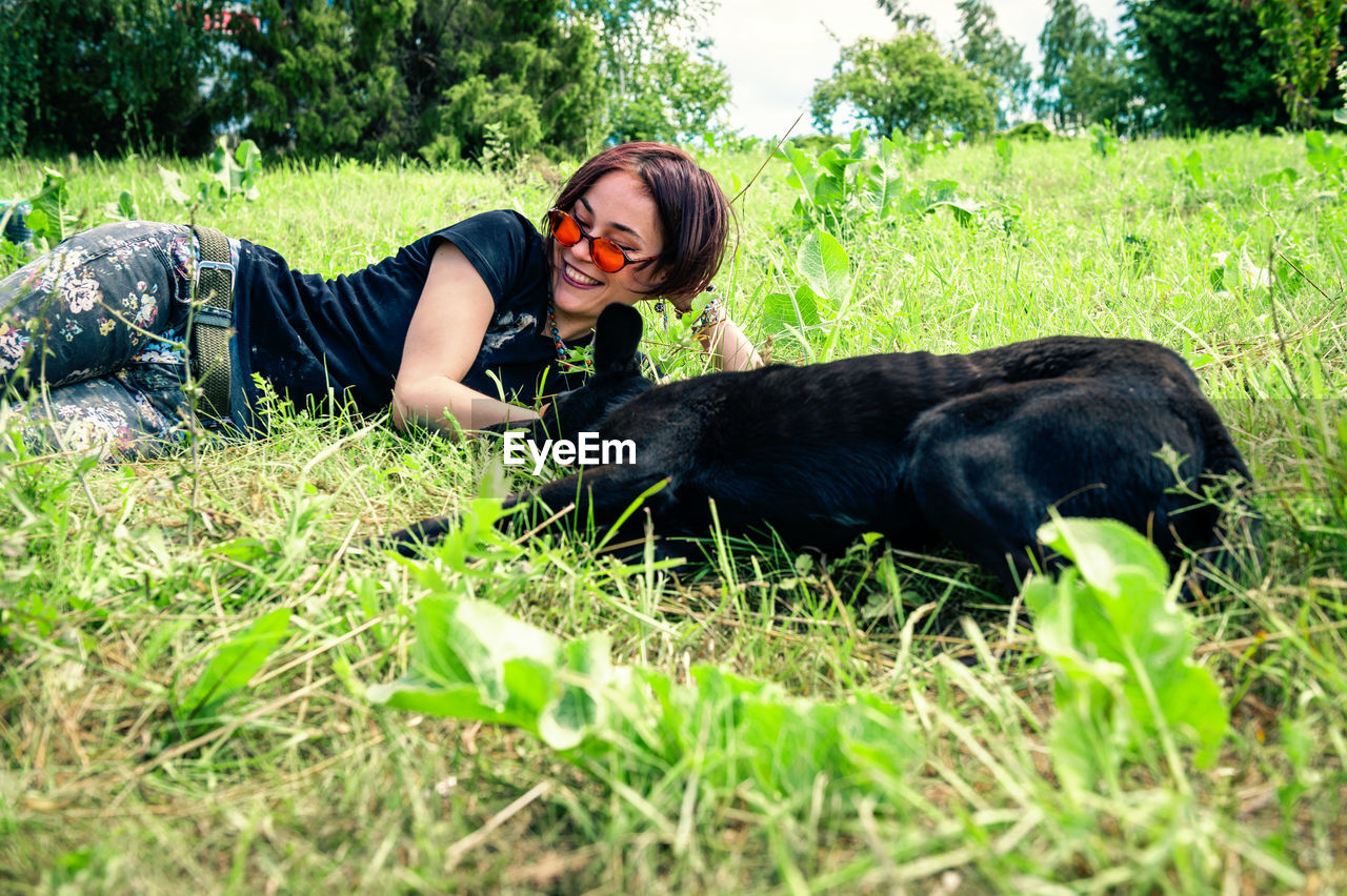 Beautiful happy woman sit and play on the lawn with her dog.  friendship concept