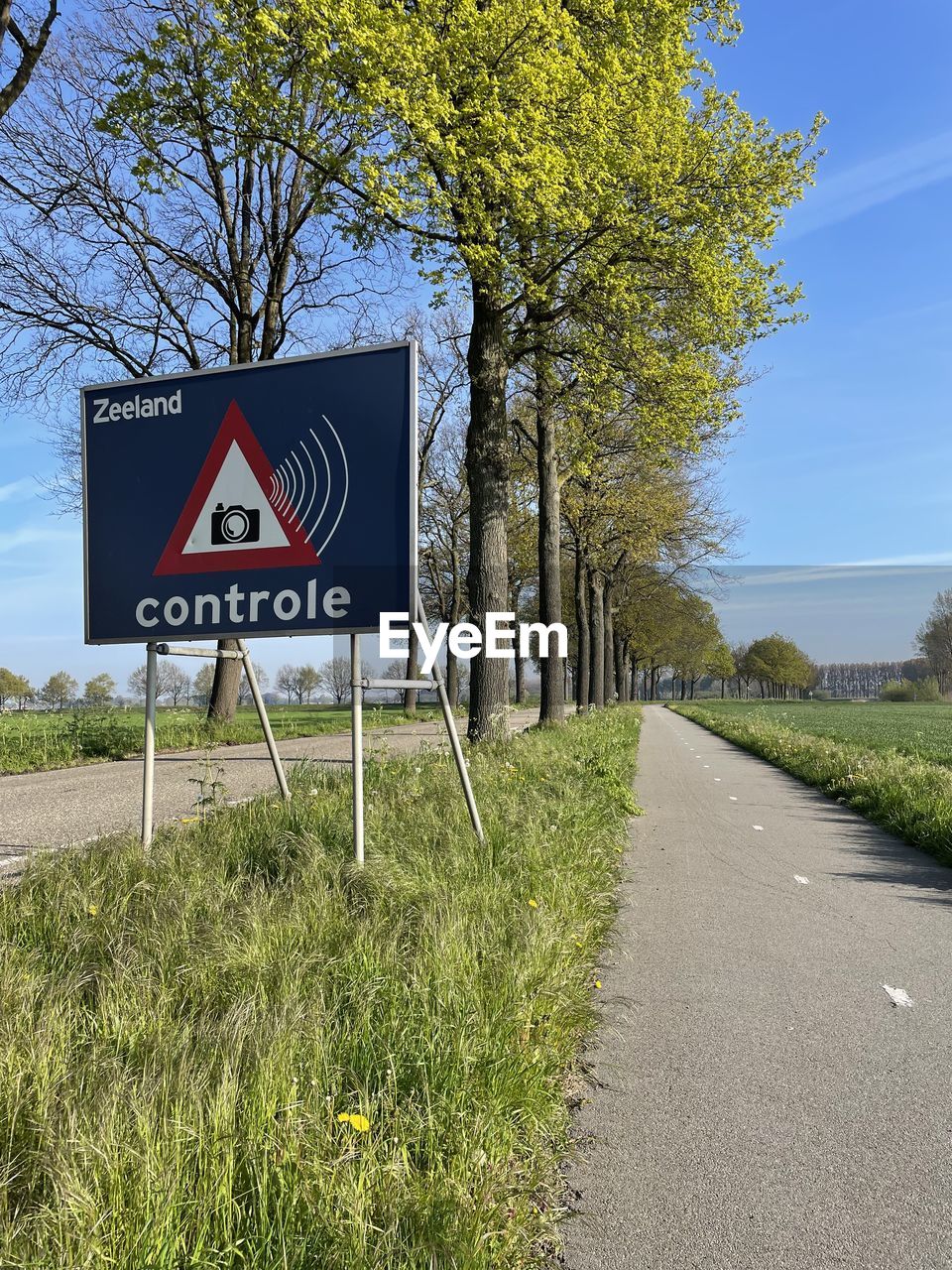 sign, plant, communication, nature, tree, no people, road, day, road sign, guidance, sky, outdoors, warning sign, information sign, symbol, text, transportation, blue, architecture, sunlight, traffic sign