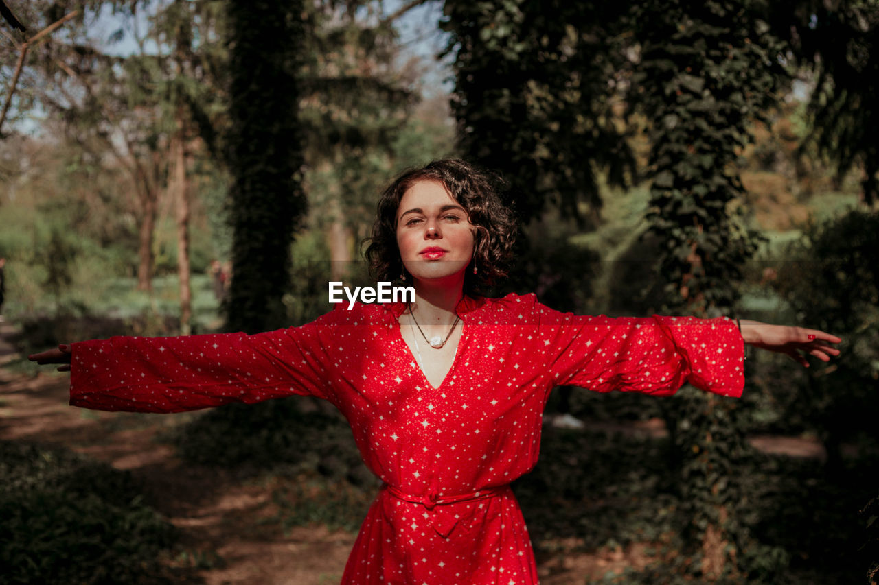 PORTRAIT OF A YOUNG WOMAN WITH ARMS OUTSTRETCHED