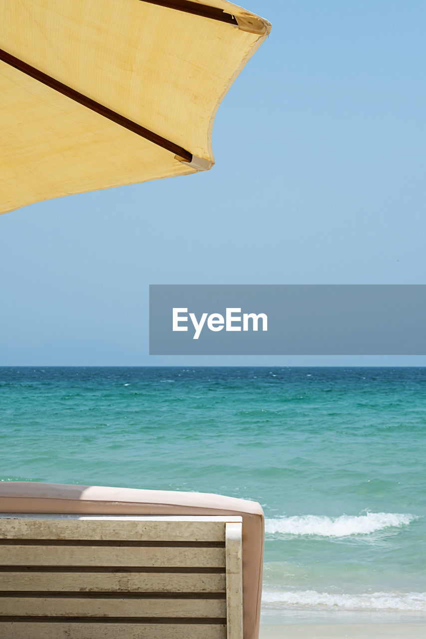 Sun lounger and beach umbrella against seascape. inspirational mood tropical resort.