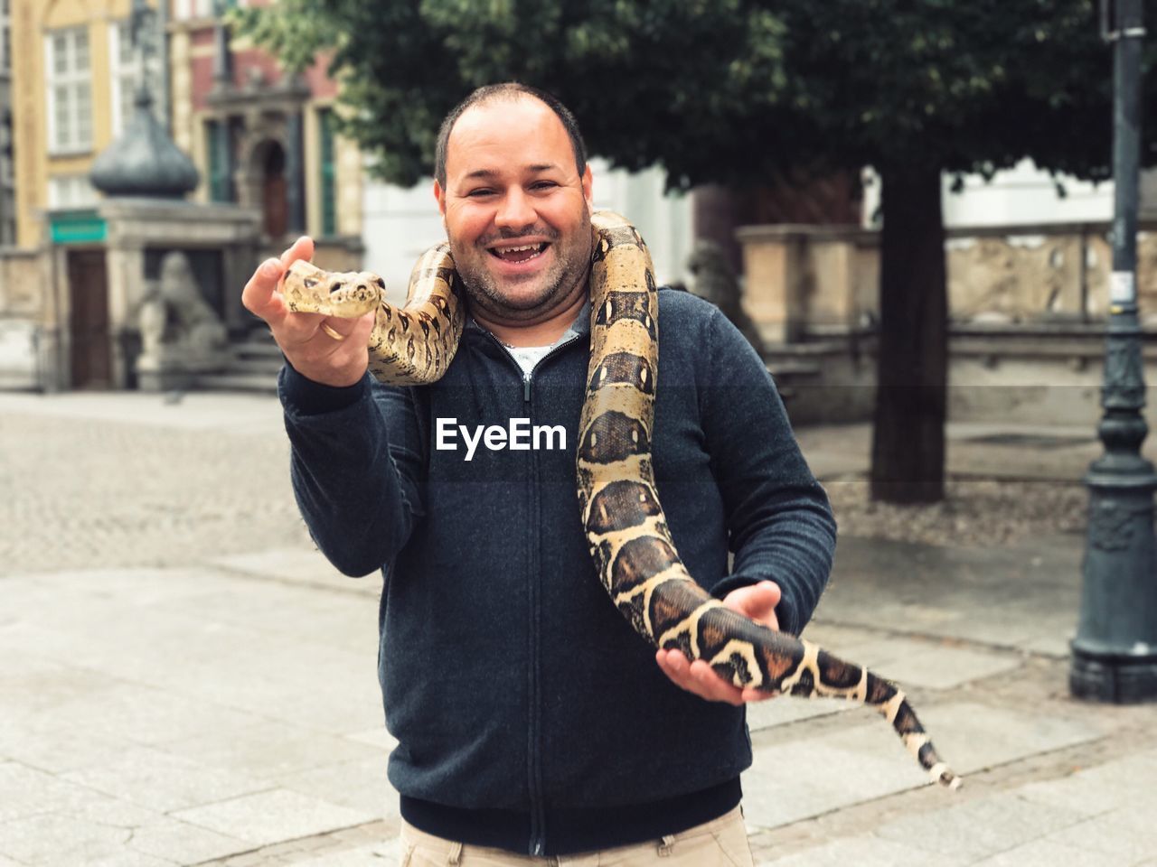 Portrait of smiling man holding snake