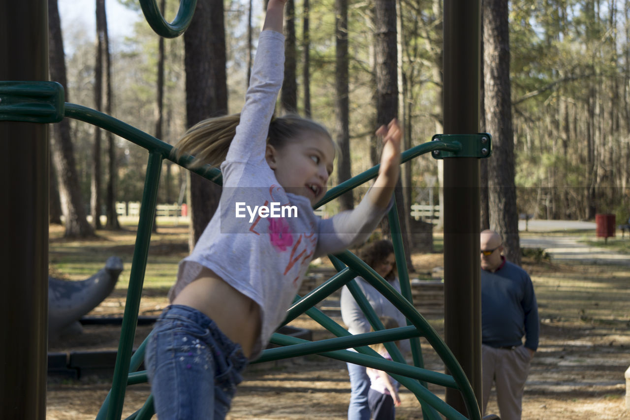 Girl playing on monkey bars at park