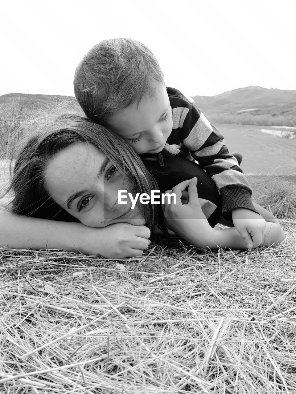 Portrait of mother lying with son on field