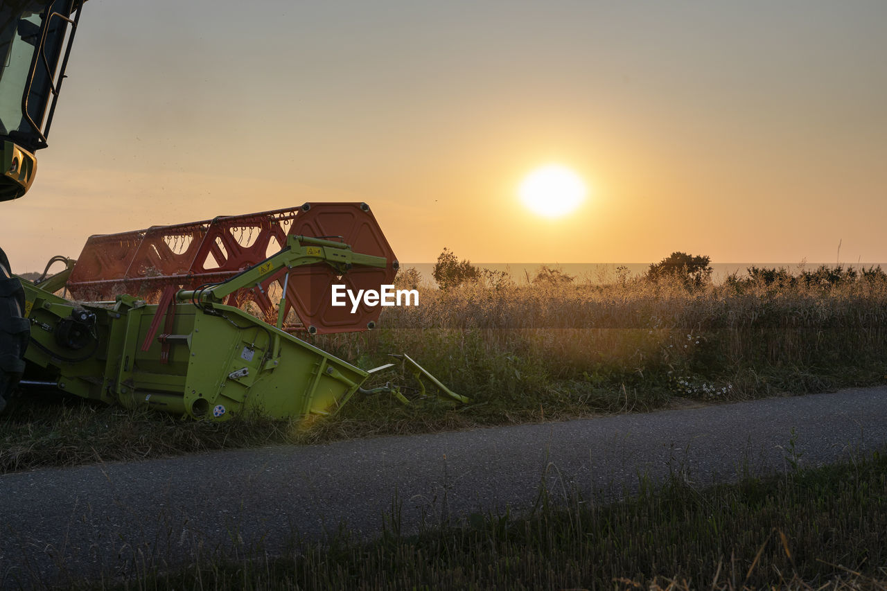 Organic farming, wheat field, harvest, combine harvester in the evening