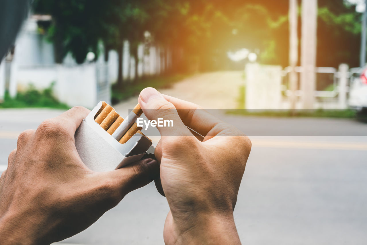 Close up man hand holding peel it off cigarette pack prepare smoking a cigarette. packing line up.