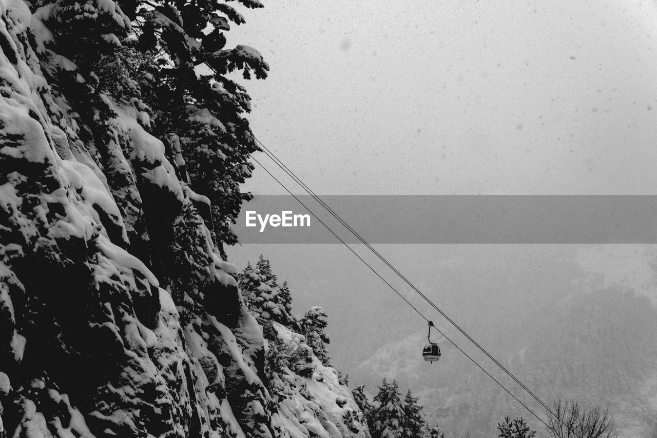 Overhead cable car on snow covered mountains during winter