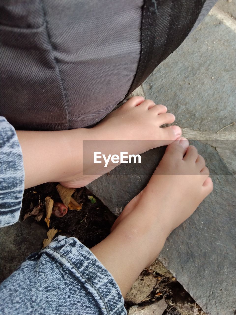 human leg, limb, adult, women, one person, low section, clothing, human limb, lifestyles, leisure activity, relaxation, high angle view, hand, casual clothing, jeans, sitting, barefoot, day, human foot, nature, footwear, toe, person, outdoors, young adult, female, fashion, close-up