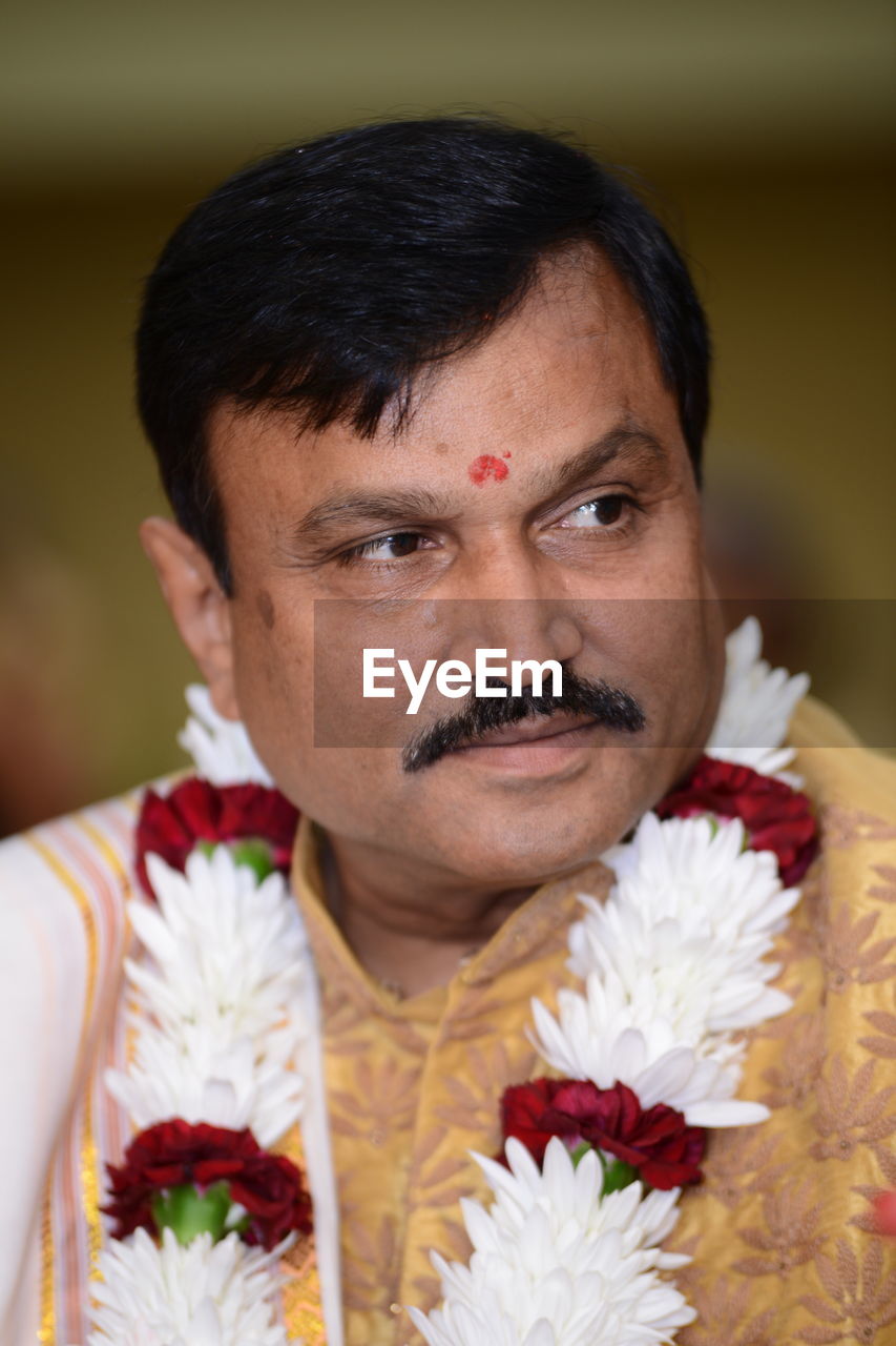 Close-up of bridegroom looking away at wedding 