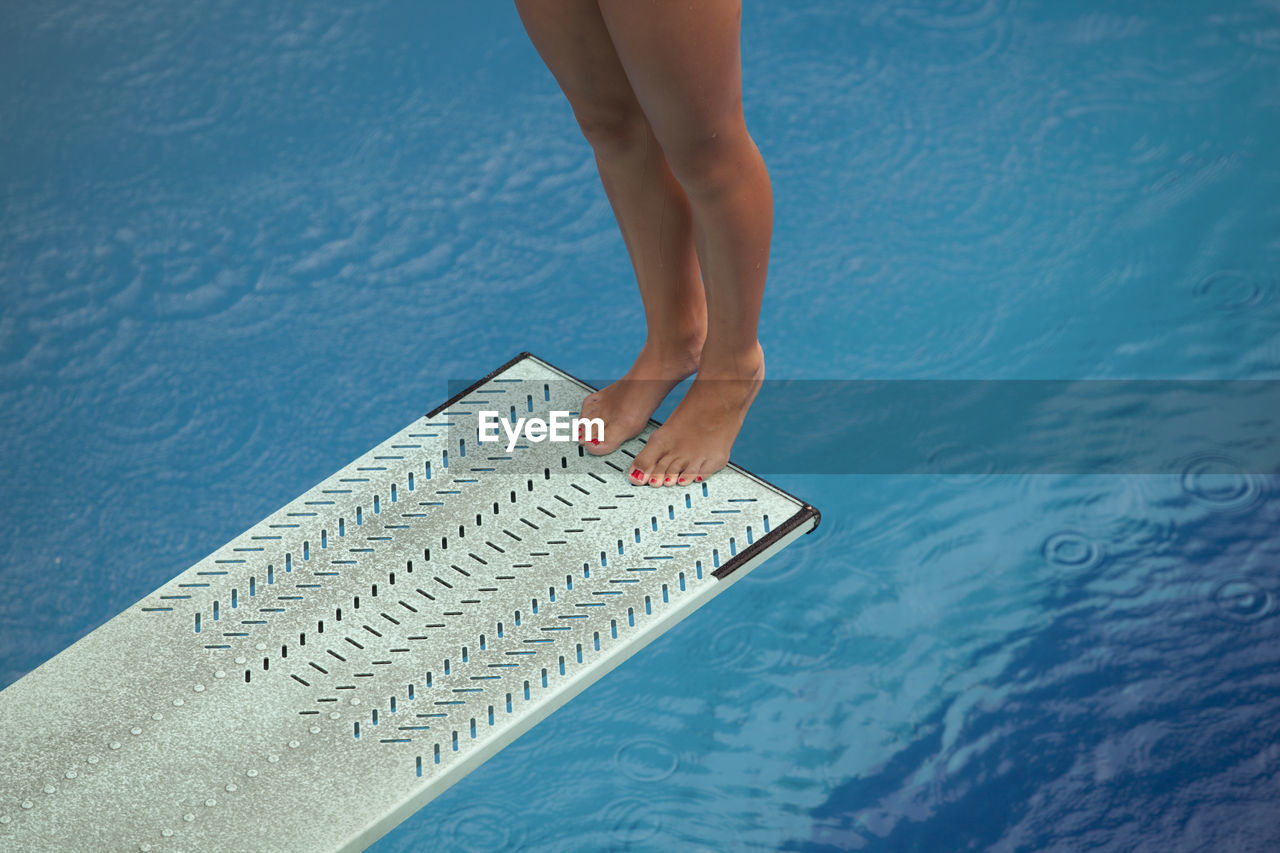 Low section of woman jumping diving board