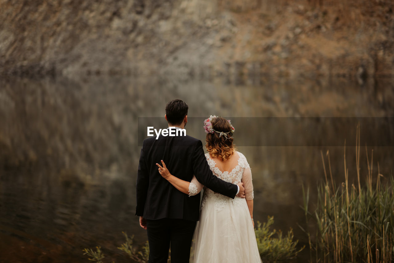 Wedding couple standing by lake