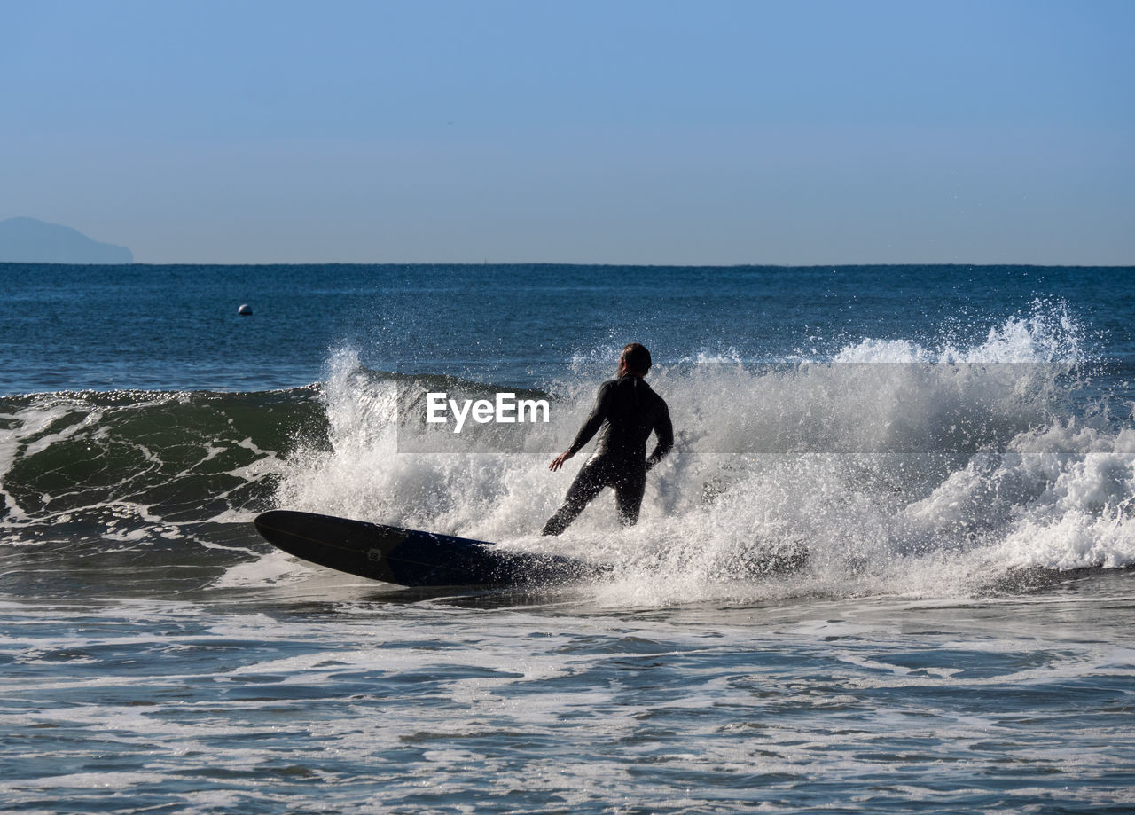 Man surfing in big wave near the coast