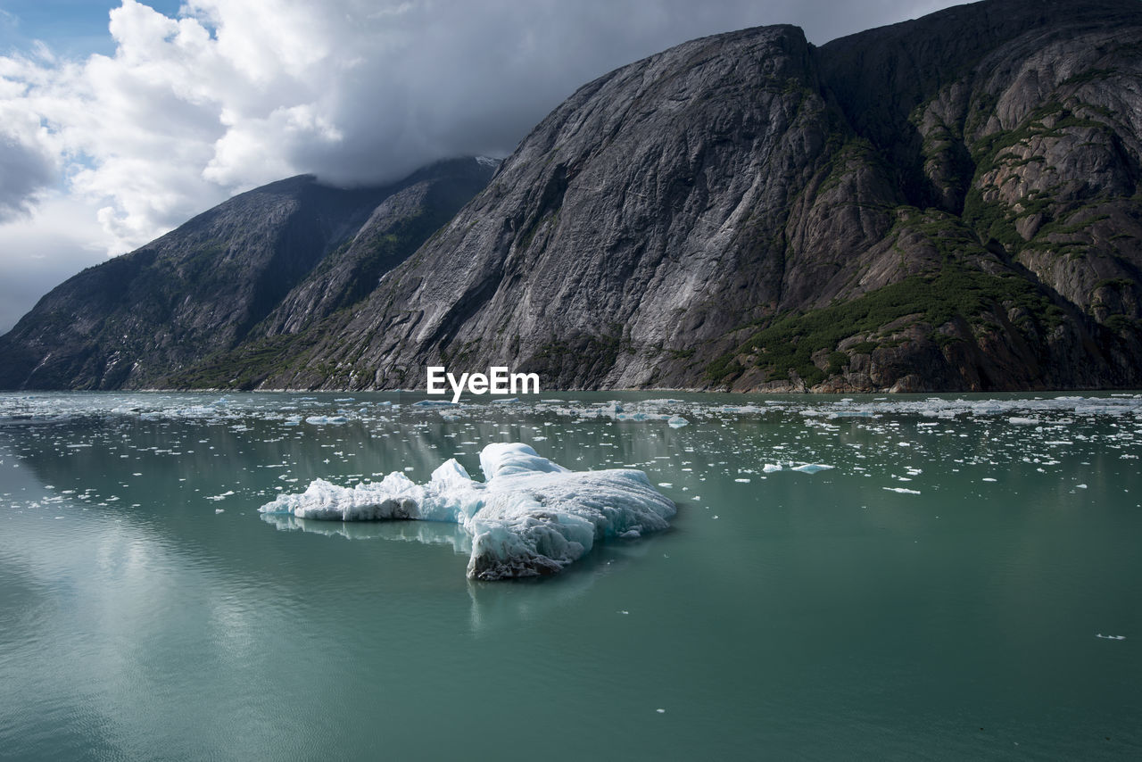 Scenic view of an alaskan iceberg and a mountain range