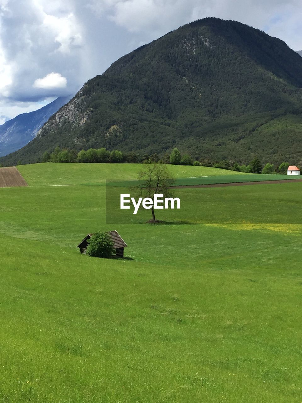 SCENIC VIEW OF GOLF COURSE ON FIELD AGAINST MOUNTAINS