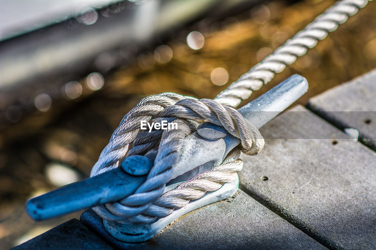 CLOSE-UP OF ROPE TIED UP ON BOAT