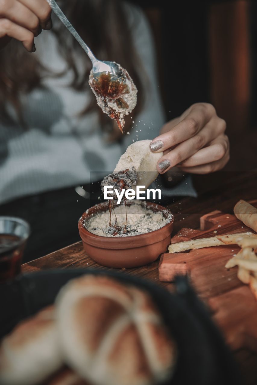 MIDSECTION OF PERSON PREPARING FOOD IN KITCHEN