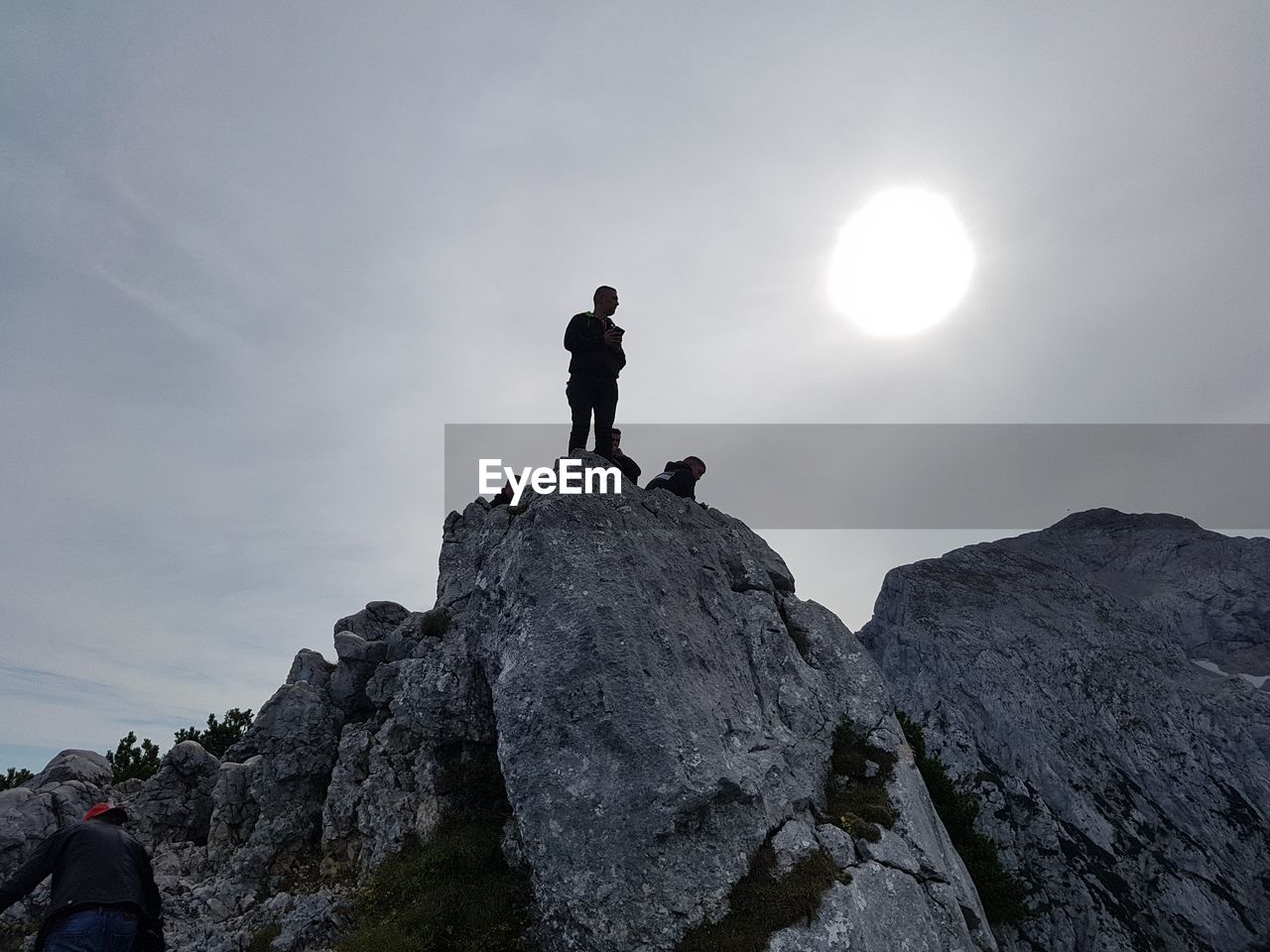 LOW ANGLE VIEW OF MAN STANDING ON ROCK