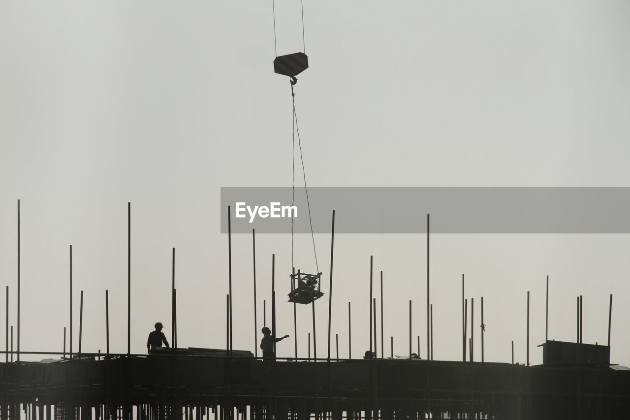 Low angle view of silhouette people against clear sky