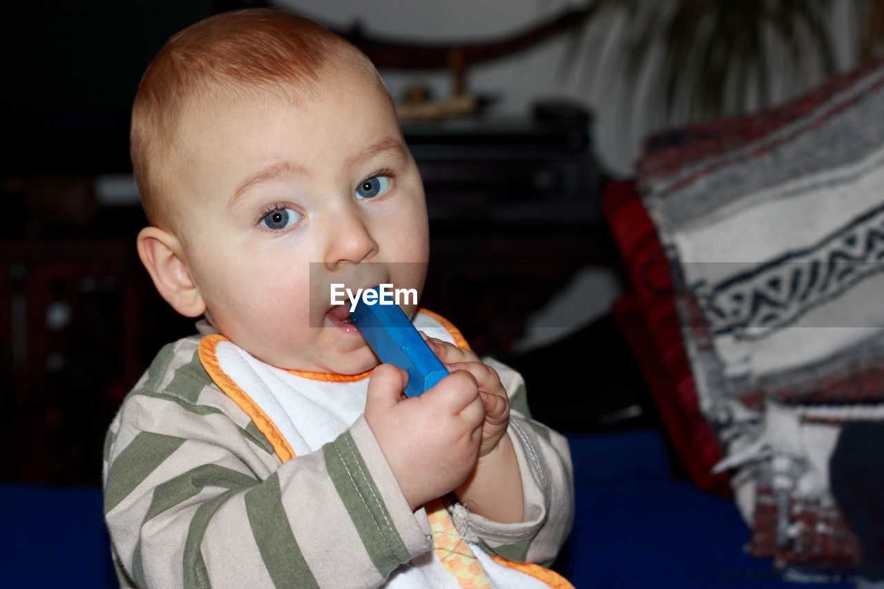 Close-up portrait of cute baby boy sitting at home