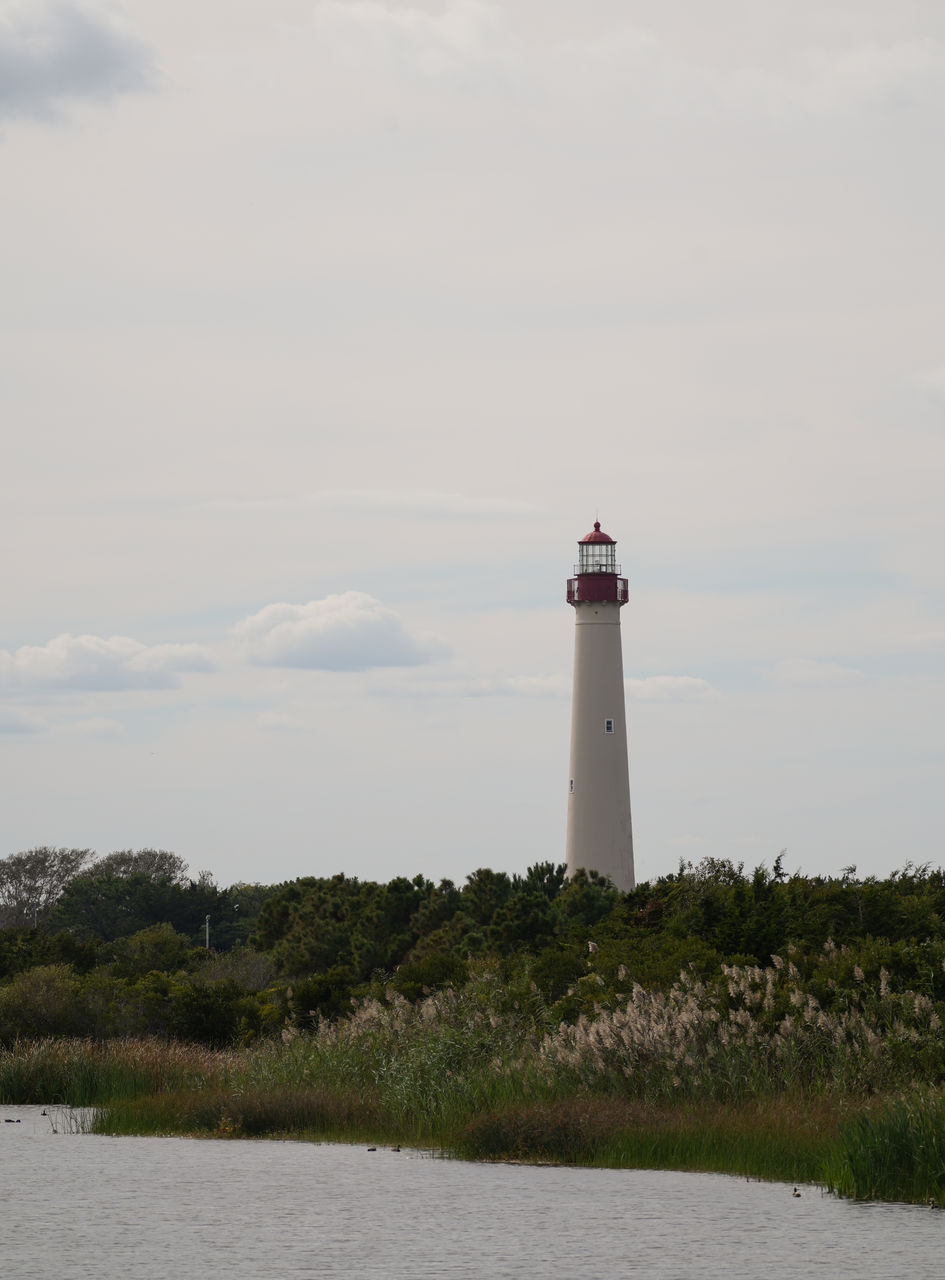 Lighthouse by sea against sky