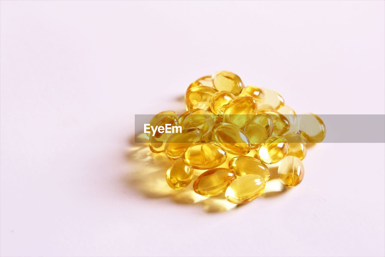 Pile of oil capsules medicine  on white background photo top view copy space 