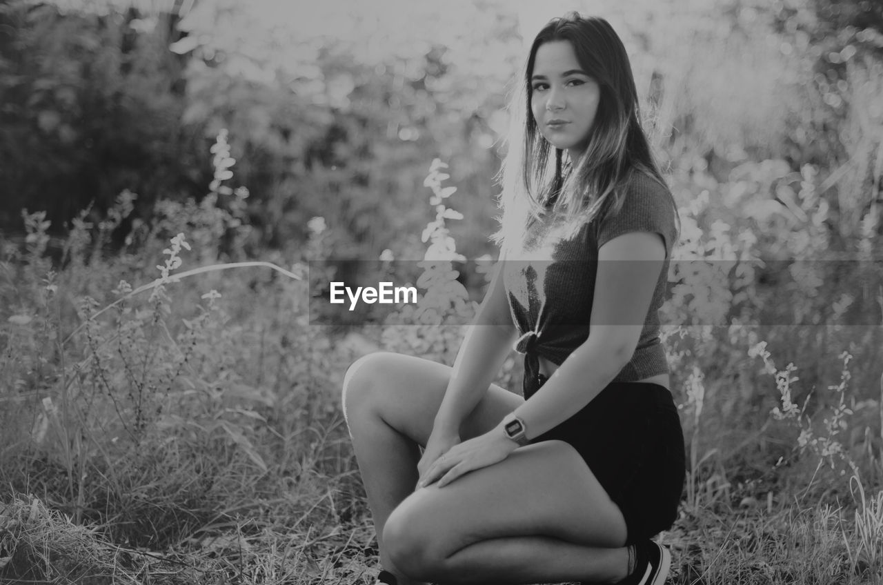 BEAUTIFUL WOMAN SITTING IN FIELD